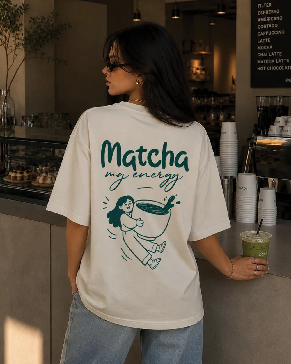 A cream YAWI tee with a hand-drawn Matcha graphic, worn in a café.