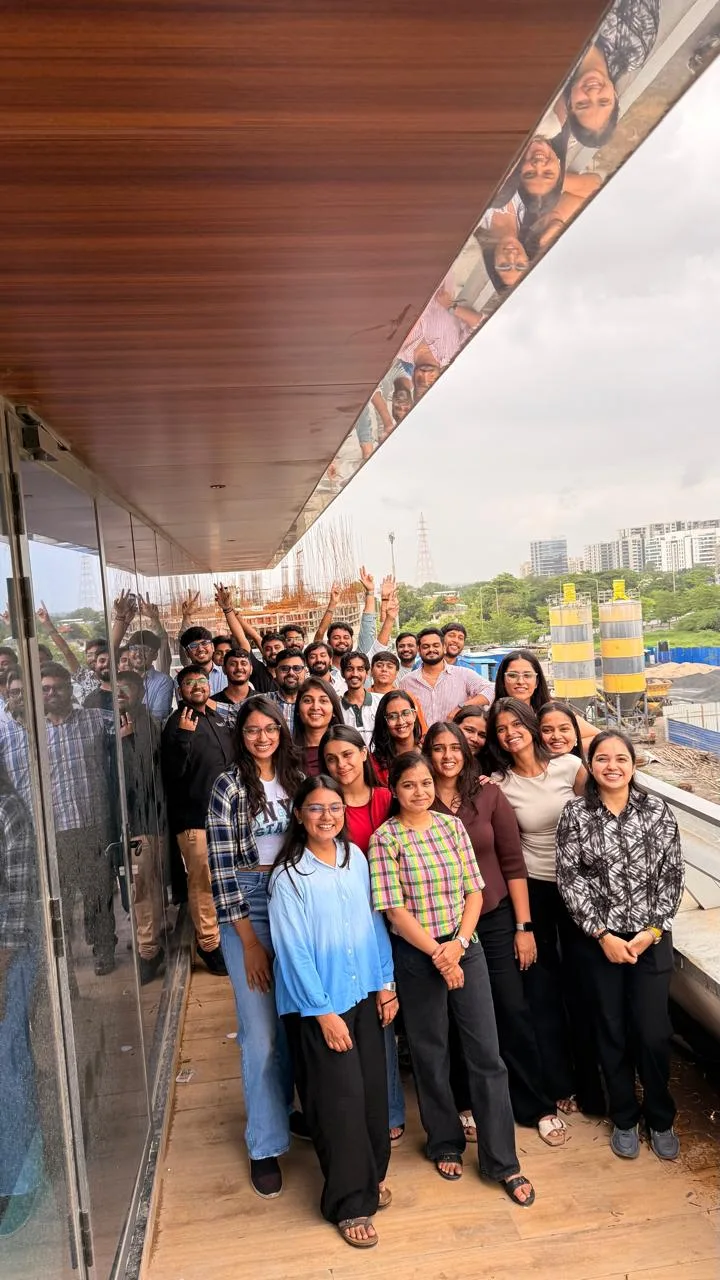 The team on the balcony, the city skyline behind them
