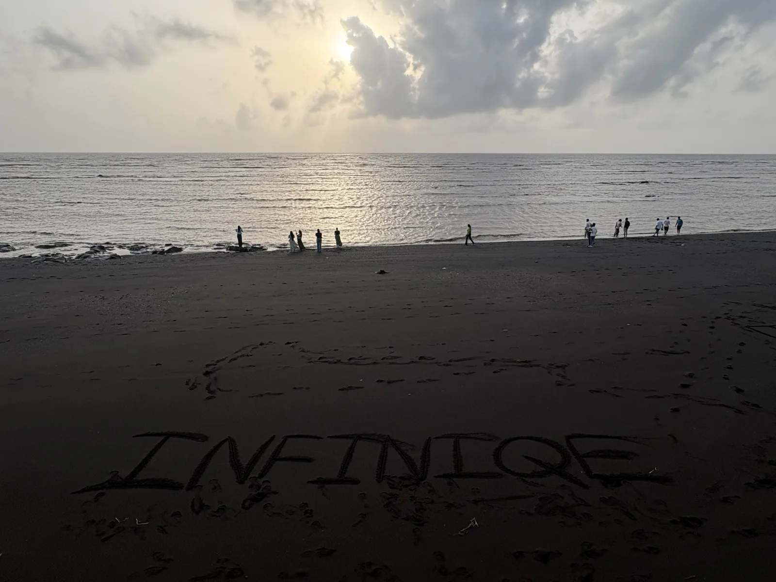 Infiniqe written in the sand on the beach