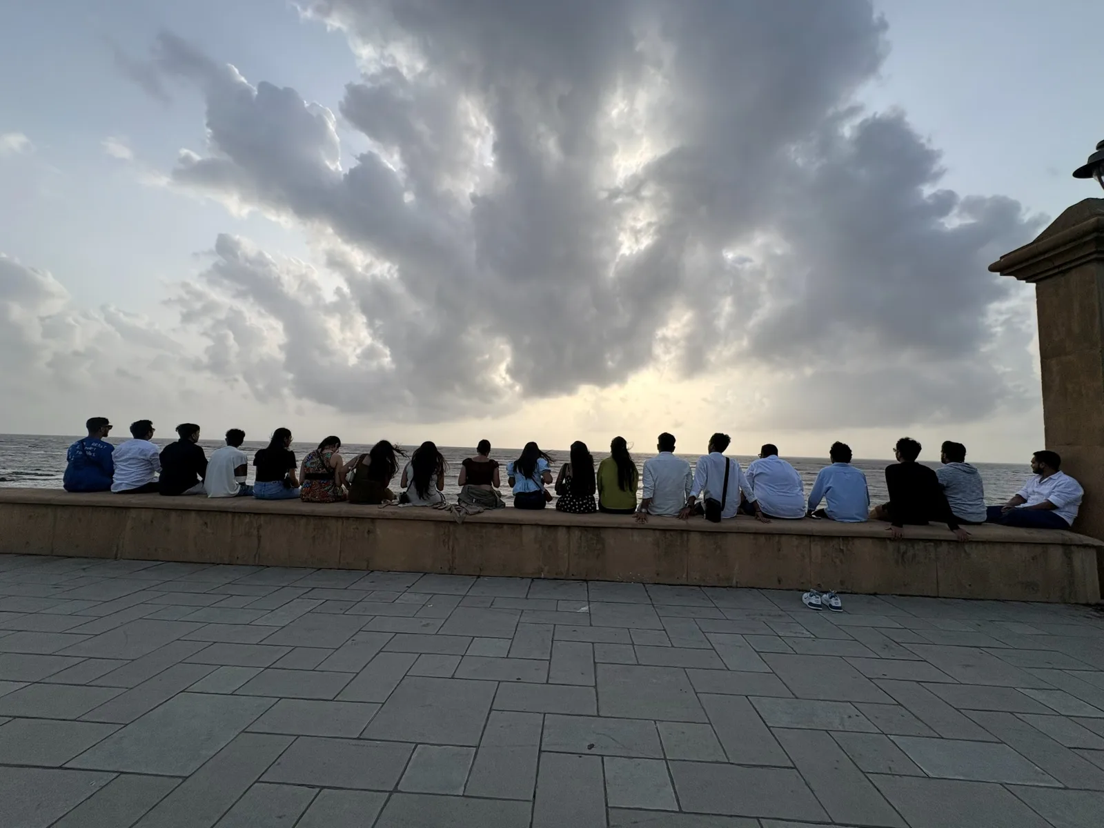 The team sitting along the seafront at sunset in Daman