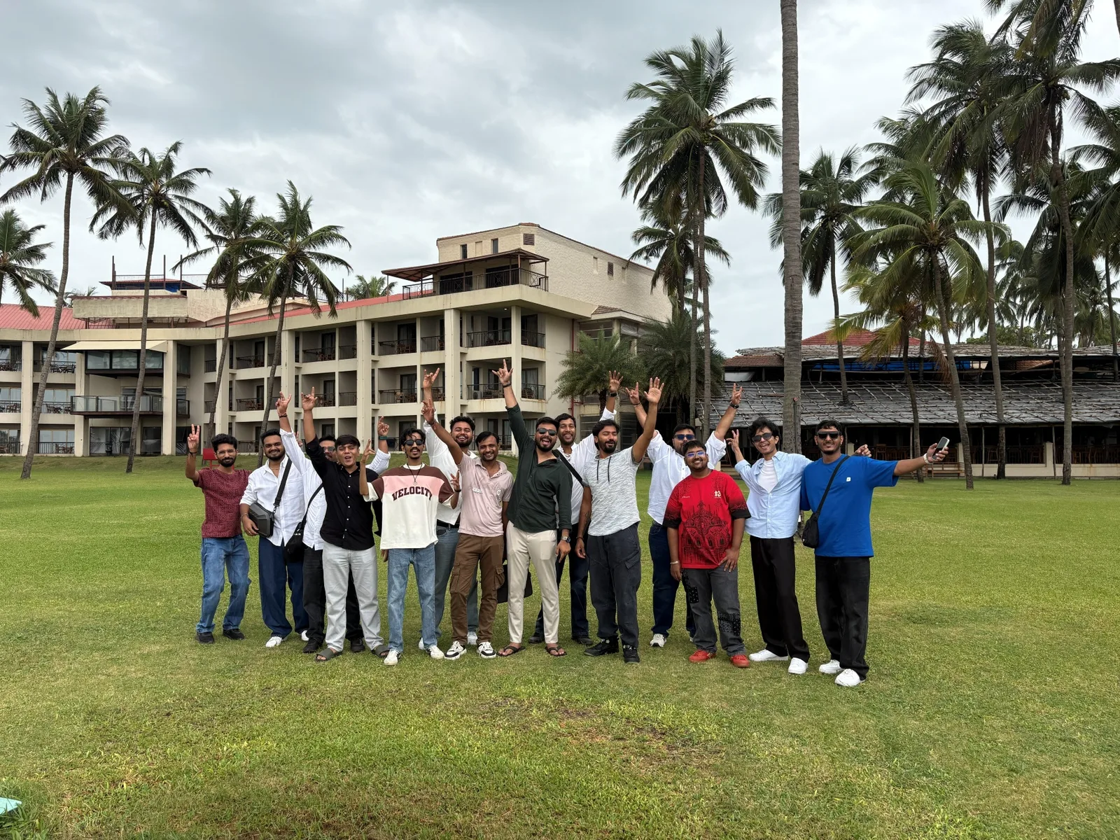 The team waving on the resort lawn in Daman