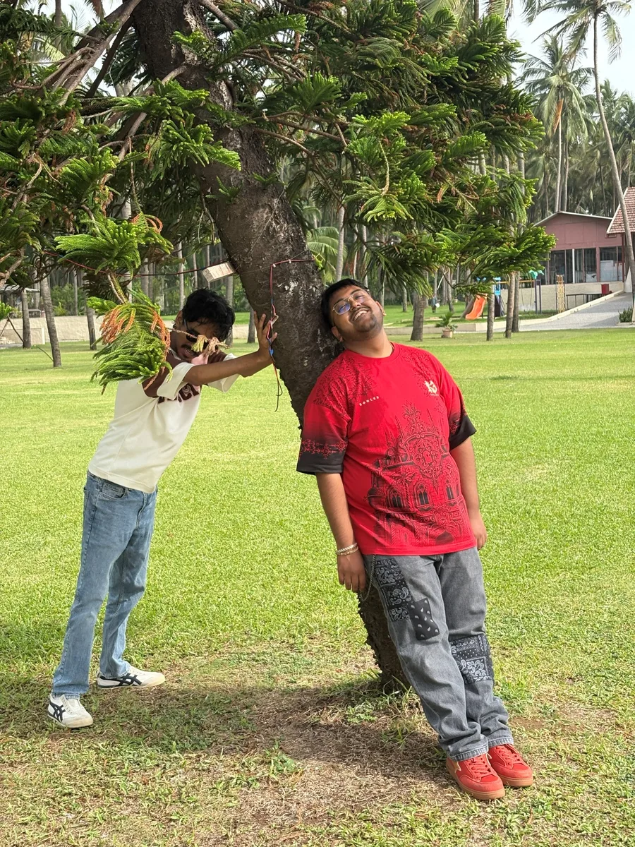 Two teammates clowning around a tree on the Daman trip